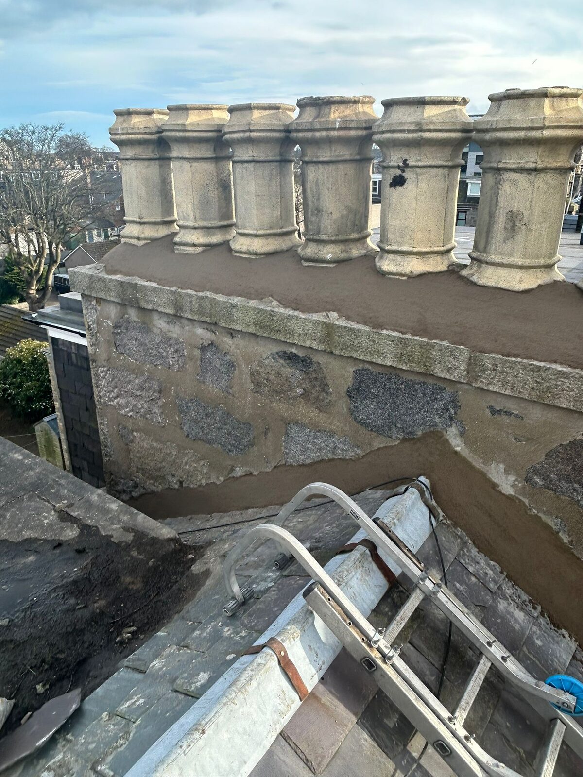 Repointed granite chimney with clay pots and new flaunching